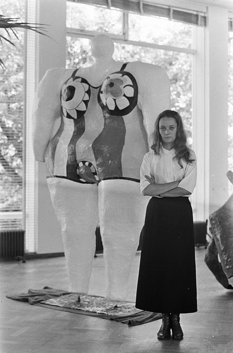 Niki de Saint Phalle, plus jeune, posant devant une sculpture Nana au Stedelijk Museum Amsterdam