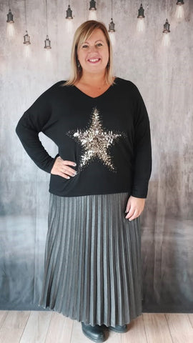 Look automne hiver en jupe longue grande taille argentee et pull noir etoile en sequin