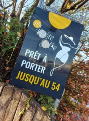 panneau publicitaire magasin de prêt-à-porter. design moderne avec des éléments graphiques élégants, une silhouette féminine stylisée portant un chapeau. mention indiquant que les vêtements sont disponibles jusqu'à la taille 54.