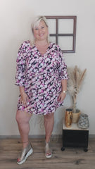 Robe ample LARA, à motifs floraux avec un fond noir et des fleurs dans les tons roses, blancs et violets
